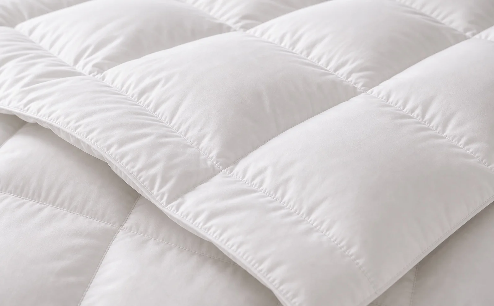 Close-up of white hotel down comforter with baffle-box stitching and loft
