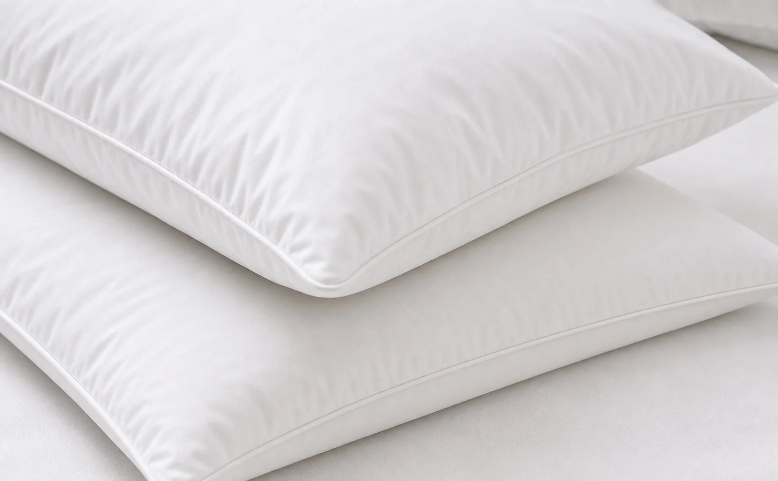 Close-up of white hotel pillow edge piping, seam stitching and soft loft